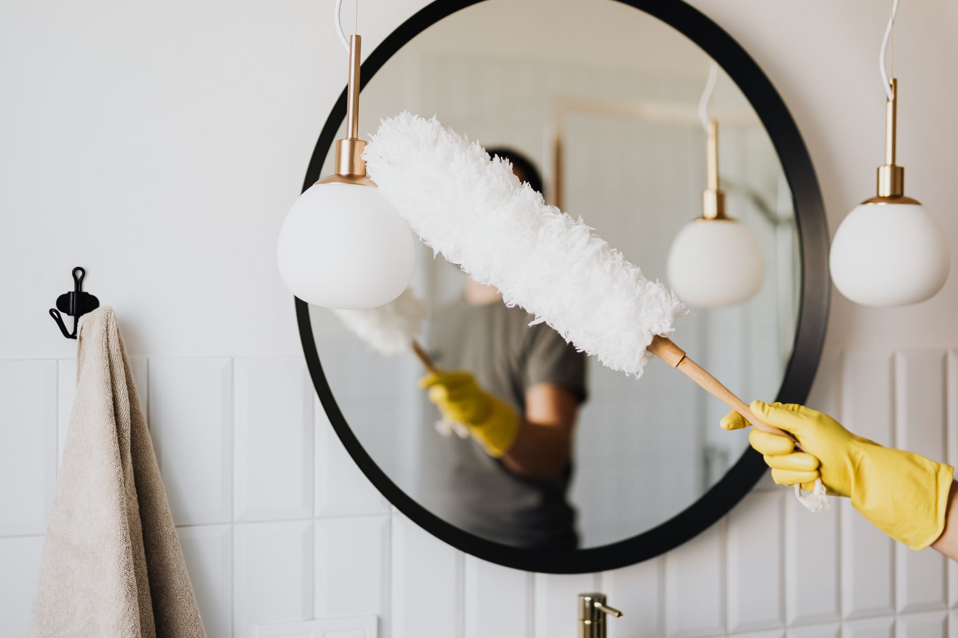 Cleaner wiping a kitchen worktop with a cloth